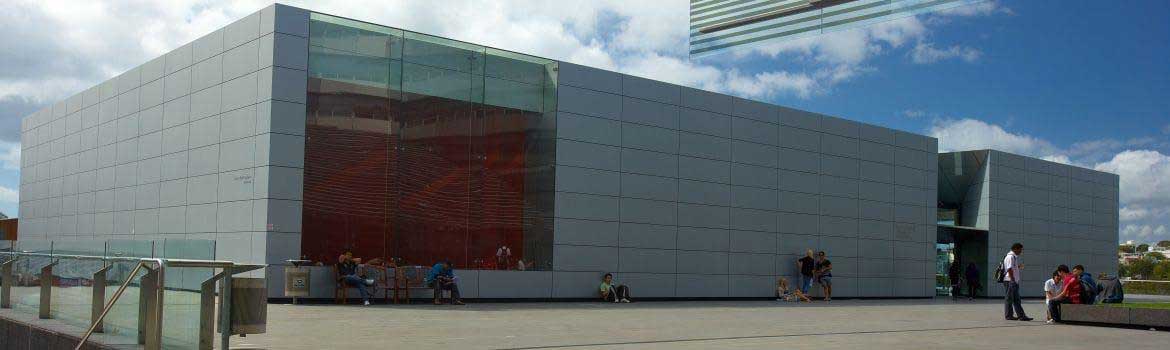 Red and silver aluminum composite panels on a glass-fronted commercial building