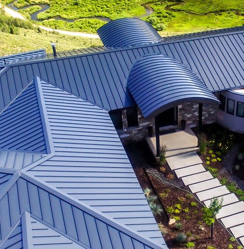 Blue standing seam metal roof panels on a building with several roof planes