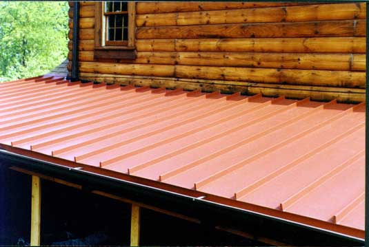 Red standing seam metal roof on a log home